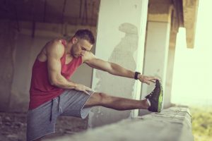 athlète musclé effectuant un étirement des jambes avant l'entraînement de musculation