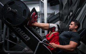 homme utilisant une presse à cuisses avec les pieds positionnés correctement
