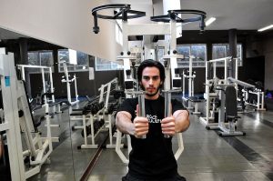 homme faisant de la musculation aux pectoraux sur une machine pec deck papillon