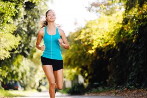 femme en running avec écouteurs sur sentier arborisé, perte de poids et forme physique