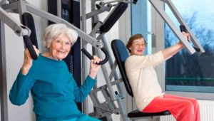 deux femmes seniors s'entraînent à la musculation en salle de sport