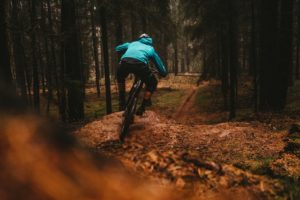 cycliste en vtt sur sentier forestier avec équipement bleu, préparation physique