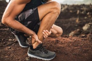 coureur se tenant la jambe souffrant d'une tendinite lors d'un entraînement