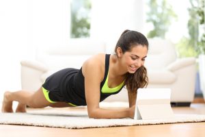 femme en planche regardant un laptop pour suivre un programme sport en ligne
