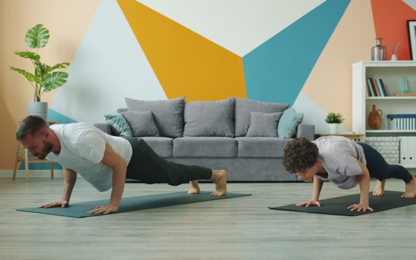 Man and woman doing push-ups on yoga mats.