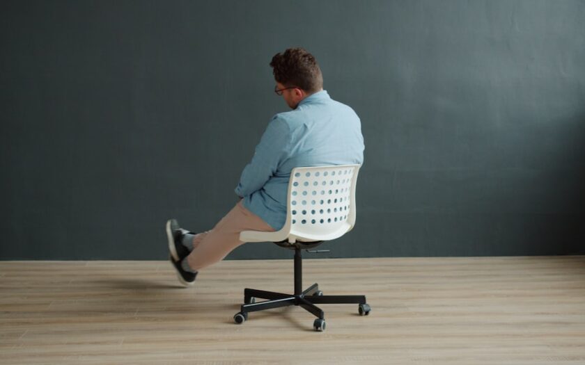 Man sitting on office chair with legs crossed