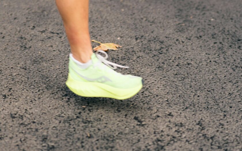 A runner's neon green shoe on a dark surface