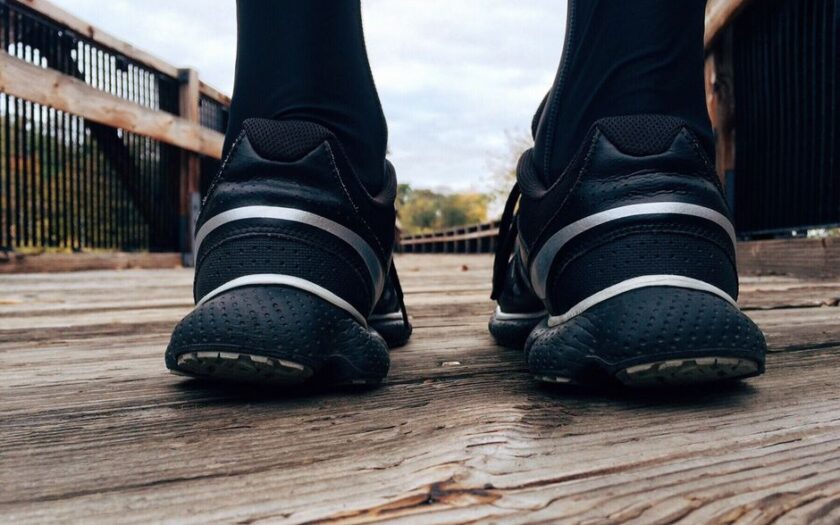 Close-up of athletic sneakers on a wooden bridge, capturing a runner's morning exercise routine.