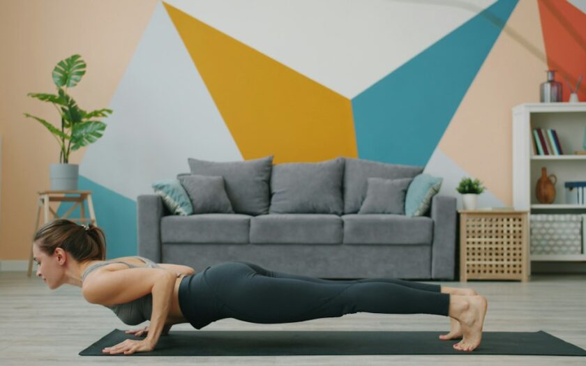 Woman doing a push-up on a yoga mat indoors